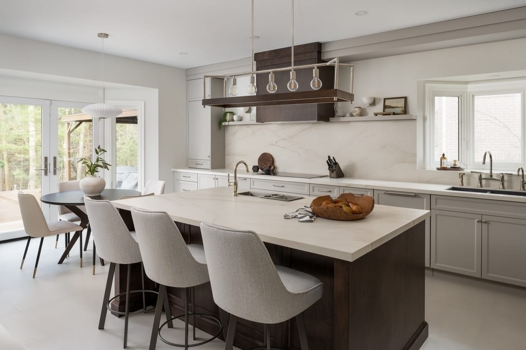 Completed kitchen remodel with a stone island, custom cabinetry and pendant lighting